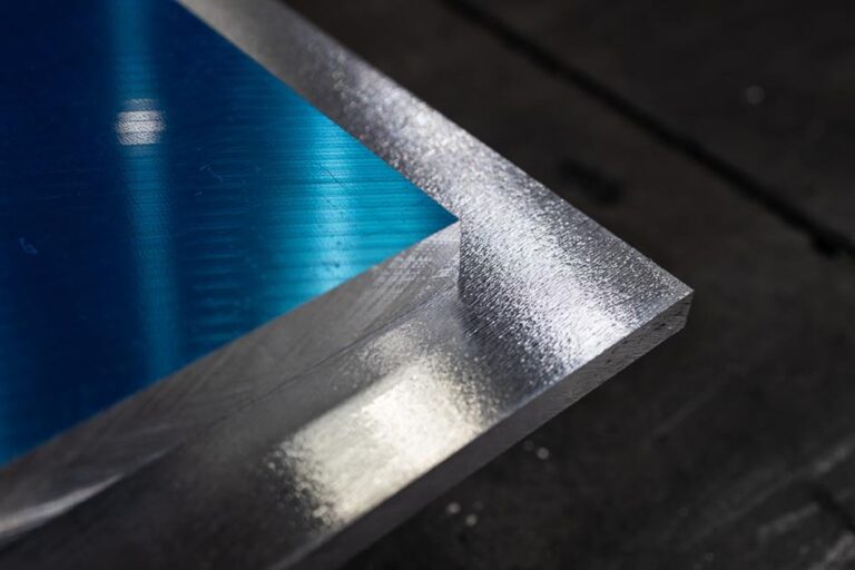 Zbliżenie na narożnik blachy aluminiowej z widocznym błękitnym odbiciem