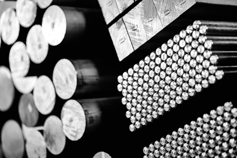 Czarno-białe ujęcie profili i cienkich prętów aluminiowych na regałach