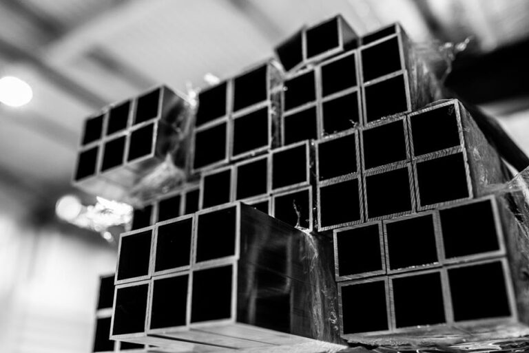 Zbliżenie na stos aluminiowych rur kwadratowych o różnych rozmiarach